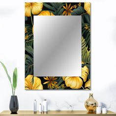 a mirror sitting on top of a wooden table next to a vase with flowers in it