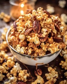 a bowl filled with caramel popcorn and pecans