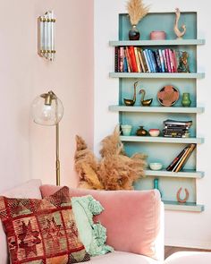 a living room filled with furniture and bookshelves next to a wall mounted shelf