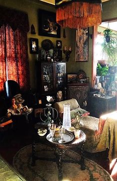 a living room filled with lots of furniture next to a window covered in drapes