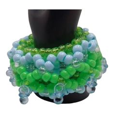 Blue and green are the star colors of this Shaker Kandi 3d cuff.  There are 10 mini blue pacifiers around this is kandi bracelet.  You just shake it to drive the no e believers crazy.   Baby blue, neon green, clear, and sparkle green. Will mail out first clasd. Adjustable Blue-green Beaded Jewelry, Green Stretch Bracelet With Colorful Beads For Party, Green Round Beads Bracelets For Party, Adjustable Green Plastic Beaded Bracelets, Adjustable Green Beaded Plastic Bracelets, Blue Plastic Party Jewelry, Green Plastic Beaded Bracelets As Gift, Plastic Beaded Jewelry For Party, Green Beaded Plastic Bracelets