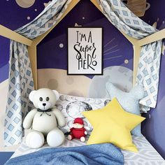 a teddy bear sitting on top of a bed next to a stuffed star and pillow