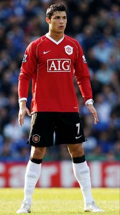 a soccer player is standing on the field with his hands in his pockets and looking down