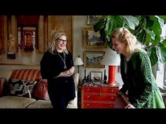 two women standing in a living room talking to each other