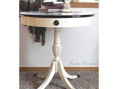 a white table with a black top and some books on the shelf next to it