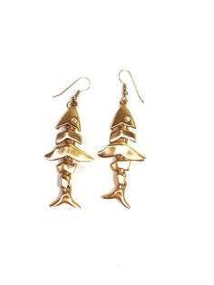 These vintage Anne Klein articulated fish skeleton earrings are absolutely fantastic! Dating to the 1980s, they are a matte, brushed-gold, and are truly a delight to wear. Almost brushing the shoulder, these sleek and modern earrings are eye-catching and elegant. As with all Anne Klein jewelry from this era, these are extremely high-quality and beautifully made. Gold-plated brass  Total length: 3in. (7.62cm.) Width: just over 1in. (2.54cm.) Made in U.S.A  Signed AK on back These earrings are in excellent vintage condition with no flaws or sign of wear.  Condition Chart: Mint: As new, with absolutely no flaws or wear. Excellent: Used, with no noticeable flaws. Very Good: Used, with minor flaws, no repairs needed. Good: Visible wear, minor flaws and/or optional repairs needed. Fair: Numerous Articulated Fish, Fish Skeleton, Skeleton Earrings, Fish Bone, Modern Earrings, Brushing, Antique Items, Anne Klein, Skeleton