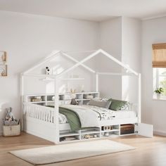 a white bed sitting in a bedroom on top of a hard wood floor next to a window