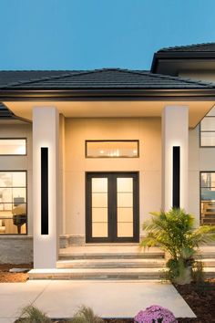 the front entrance to a modern home at dusk