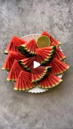 slices of watermelon arranged on a plate with a lime slice in the middle