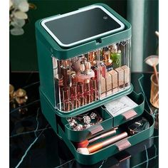 an assortment of cosmetics and lipstick in a green case