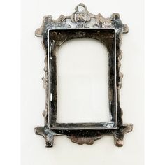 an old metal frame hanging on the wall with a chain around it's edges