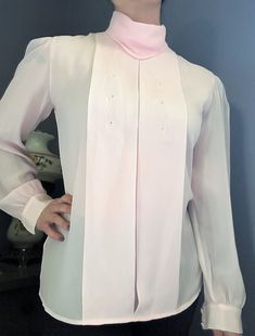 This long sleeve light pink blouse features a beautiful embroidered design and wide pleats on the front. It buttons down the back. It is estimated to have been made in the 1980s and is 100% polyester. This blouse would be wonderful for casual or professional looks for spring and summer. Brand: Kelley Scott Size/Measurements: This blouse's tag reads size 6. When laying flat, the blouse measures 19.5 inches across the bust and 25.5 inches in length. Friendly reminder: due to age and wear, vintage clothing can be slightly discolored, have minor stains, missing buttons, loose threads etc. PLEASE NOTE: Returns are not accepted for clothing items for health safety reasons. If you have questions about measurement, size, or fit, please contact me. Buying vintage items is not only a great way to re Elegant Long Sleeve Pink Blouse, Elegant Pink Long Sleeve Blouse, Pink Long Sleeve Formal Blouse, Pink Long Sleeve Formal Top, Pink Long Sleeve Blouse For Daywear, Pink Long Sleeve Blouse For Formal Occasions, Formal Long Sleeve Pink Tops, Vintage Pink Blouse For Formal Occasions, Vintage Pink Long Sleeve Blouse