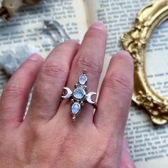 moon ring, witchy jewelry, moonstone ring, crescent moon, moon witch, lunar love, crystal jewelry, fantasy jewelry, silver ring, ooak ring Three moonstones sit in a line and are flanked by two crescent moons. The moons have been textured to add that extra contrast to the shiny stones.  The ring is a size 7 US.  All components of the ring and hand fabricated in sterling silver and plated with 18k white gold.  The back settings of the stones are open to allow natural light to pass through.  Please message me if you have any questions! Magical Moon Shaped Ring With Moon Phase Detail, Celestial Moonstone Ring With Moon Charm, Magical Moon Shaped Ring With Moon Phase, Magical Moon-shaped Ring With Moon Phase Details, Magical Moon-shaped Ring With Moon Phase, Magical Moon Phase Moon-shaped Ring, Mystical Crescent Rings With Moon Charm, Silver Moonstone Ring With Moon Phase, Mystical Crescent Moon Charm Rings