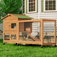 an outdoor chicken coop in the grass with two chickens inside and one on it's side