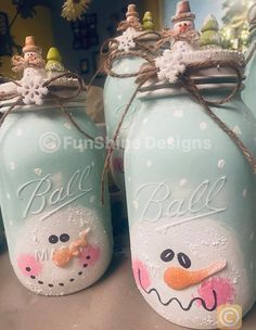 two blue mason jars with snowmen painted on them