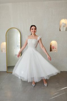 a woman in a white dress posing for the camera