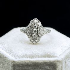 an antique diamond ring sitting on top of a white box