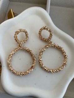 ✨Indulge in the ultimate expression of luxury with our Elsa Gold Earrings. ✨These captivating pieces feature a double-hoop design, intricately textured to catch the light from every angle. ✨Bold yet elegant, they exude a sultry sophistication that elevates any look. ✨Perfect for those who demand attention and embrace their inner radiance, the Elsa earrings are more than just an accessory—they're a statement. Let your allure shine through with every wear. Hoop Design, Ring Necklace, The Light, Gold Earrings, Texture, Gold, Design