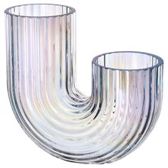 a clear glass vase sitting on top of a white table next to a metal pipe