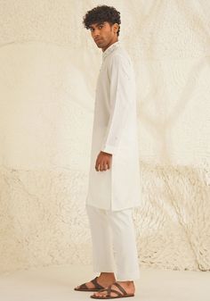 Presenting an exquisite Porcelain White Silk Kurta Set, featuring a sophisticated Chinese collar, elegant metallic silver buttons, and intricate hand-embroidered detailing on the neckline and sleeves. Paired with trendy white pants, this ensemble is perfect for engagements, Roka ceremonies, or puja events, combining timeless elegance with contemporary style. Composition : Dupion Silk Care: Dry Clean Only and Vacuum Storage This product can be customized for sleeves, length and colour Delivery : 4-6 weeks as the product is hand crafted. Check Size Guide or choose MySize for free customisation (All Sizes above XL can be made at 15% additional cost) For more information and sizes please contact fabiliciousfashion@gmail.com or visit our Copenhagen studio. About the Designer : Shreyansh, a dist Classic Long Sleeve Traditional Formal Wear, Elegant Semi-formal Sets For Eid, Classic Formal Traditional Wear For Eid, Classic Unstitched Traditional Wear For Formal Occasions, Elegant Straight Kurta With Set-in Sleeves, Fitted Kurta With Set-in Sleeves For Festive Occasions, White Straight Kurta With Pearl Embroidery, Festive Kurta With Set-in Sleeves, Classic Bandhgala For Eid Festivities