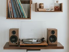 a record player sitting on top of a wooden shelf