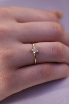 a woman's hand with a ring on it and a star shaped diamond in the middle