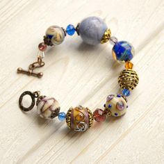 "This Lavender boho bracelet bracelet is a perfect gift for women. It's very tender and unique! This lampwork bracelet fits a 15.5-16.5cm (6.1\"-6.5\" inch) diameter wrist. If you need bigger or smaller size bracelet, please, write me the diameter of your wrist when making an order. Dimentions: 21cm. Materials: artist lampwork beads, metal and glass beads, metal fittings. Colors used: blue, lavender, lilac. Please, note, each lampwork bead is made by hand and may differ slightly. All the photos Adjustable Bohemian Crystal Bracelet With Czech Glass, Bohemian Czech Glass Beaded Crystal Bracelet, Bohemian Bracelets With Spacer Beads For Gift, Bohemian Bracelets With Spacer Beads As Gift, Bohemian Jewelry With Large Glass Beads, Bohemian Beaded Bracelets With Faceted Beads For Jewelry Making, Bohemian Beaded Bracelets With Czech Glass As Gift, Bohemian Czech Glass Crystal Bracelet With Spacer Beads, Bohemian Crystal Bracelet With Czech Glass Faceted Beads