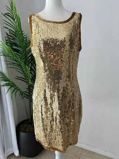 Stunning, gold sequin, mini, sleeveless, shift dress, perfect for New Years Eve. In overall great vintage condition, with only notable issue being a tiny patch of missing sequins on the back near the right arm pit, easily replaceable and not very noticeable. Dress is fully lined and zips up the back with a hook and eye closure at the top. No designers tag or labels, would best fit a modern size 8-10.   Measurements Chest 40in/101.5cm Waist 32in/81.5cm Hips 40in/101.5cm Length 36in/91.5 (strap to Gold Embellished Sleeveless Mini Dress, Gold Embellished Sleeveless Sequin Dress, Gold Embellished Mini Sequin Dress, Gold Sleeveless Mini Dress With Contrast Sequin, Gold Embellished Mini Dress For Holiday, Holiday Gold Embellished Mini Dress, Gold Mini Dress With Contrast Sequin For Summer, Gold Sleeveless Sequin Summer Dress, Gold Sleeveless Sequin Dress For Summer