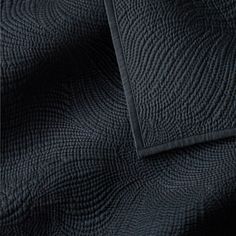 an image of a black quilted bed spread