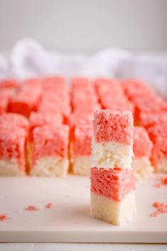 two pieces of red and white cake sitting on top of each other with the words, sweet & simple coconut ice bites