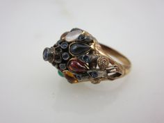 "A lovely vintage 18k gold and multi stone ring, featuring mainly sapphires. The style is known as a Thai Princess ring, with it's gemstone studded pointy top. Marked \"18k\". US size 5.5 and is resizable at any jeweler. Actual packaging will vary depending on item/s purchased and tape pattern available. Props shown in photos is for display purposes only, not included in this listing. As always, satisfaction is guaranteed. Thanks for shopping Vintage In Bloom More rings: http://www.etsy.com/shop Tape Pattern, Princess Ring, Gemstone Studs, Multi Stone Ring, Multi Stone, Rings For Women, Ring Gold, In Bloom, Stone Ring