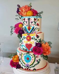 a multi - tiered cake decorated with colorful flowers