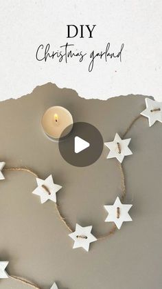 a candle that is sitting in the middle of some stars on a string with words diy christmas garland