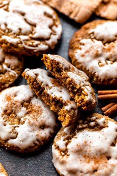 several cookies with white icing and cinnamon sticks