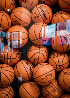 many basketballs are stacked together in a pile