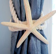 a white starfish hanging from the side of a curtain