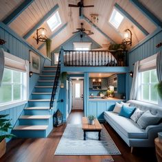 a living room filled with furniture and a staircase leading up to the top story window