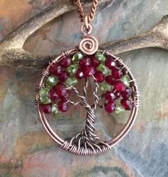 This unique & gorgeous wire wrapped Tree of Life pendant necklace. The pendant is made with deep red Garnet & Peridot gemstone using antiqued copper wires. The pendant measures about between 1.35 to 1.40 inch  in diameter. It comes with your choice of an antiqued copper finished chain, Deerskin Lace leather or genuine black leather necklace Each pendant is handmade, so please allow slight variations from the shape of the branches and placement of the stones as shown. The Tree of Life is a universal symbol found in many spiritual traditions around the world. The tree of knowledge, connecting to heaven and the underworld, and the tree of life, connecting all forms of creation, are both forms of the world tree or cosmic tree. It's meaning represents life itself, wisdom, love, strength, protec Red Wire Wrapped Copper Jewelry, Red Copper Wire Wrapped Jewelry, Artisan Wire Wrapped Red Jewelry, Hand Wrapped Wire Necklaces For Gifts, Artisan Red Wire Wrapped Jewelry, Hand Wrapped Wire Necklace For Gift, Gift Necklace With Wire-wrapped Design, Red Copper Wire Jewelry Gift, Red Hand Wrapped Necklace As Gift