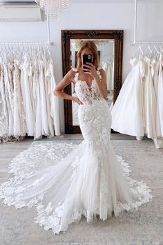 a woman taking a photo of her wedding dress