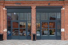 the front entrance to a brick building with large windows