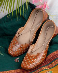 Introducing our "Zendaya" Punjabi jutti, a true epitome of elegance and style meticulously handcrafted by skilled artisans using pure leather. This exquisite footwear features a timeless tan color adorned with unique gold jari work on the stylish upper, creating a mesmerizing blend of tradition and modernity. Each stitch of the "Zendaya" jutti is a testament to the dedication and skill of our artisans, ensuring impeccable quality and attention to detail. The simplicity of its design is complemented by the sweetness of its charm, making it a versatile accessory that effortlessly attracts attention wherever you go. Wearing the "Zendaya" jutti, you'll exude confidence and grace, knowing that you're adorned in a piece of artistry that reflects your unique sense of style. Its understated yet ca Juti Shoes Pattern, Brown Open Toe Sandals For Wedding, Leather Flats With Leather Sole For Wedding, Leather Wedding Flats With Leather Sole, Leather Flats For Wedding, Traditional Festive Sandals With Single Toe Strap, Traditional Sandals With Single Toe Strap For Festive Occasions, Festival Sandals With Cutdana And Round Toe, Leather Sandals With Dabka And Round Toe