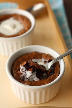 two bowls filled with dessert on top of a wooden table