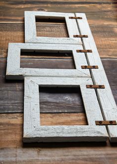 an unfinished wooden frame with metal clips on the bottom and one piece cut out to look like a cross