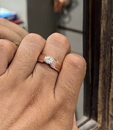 a man's hand with a wedding ring on his finger, in front of a door