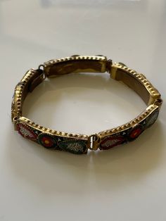 A vintage micro mosaic base metal bracelet, circa 1930-40. Antique Enamel Bracelet Collectible, Vintage Adjustable Bracelets With Intricate Design, Vintage Gold Jewelry With Meenakari, Vintage Gold Meenakari Jewelry, Vintage Brass Bracelet With Intricate Design, Retro Multicolor Bracelet Jewelry, Festive Antique Style Metal Bracelets, Vintage Gold Enamel Bracelets, Antique Enamel Bracelet Jewelry