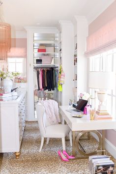 a white desk sitting next to a closet filled with lots of clothes and other items