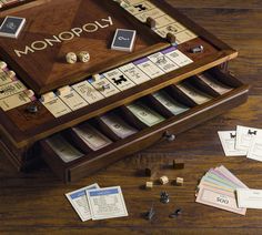 a monopoly board game on a wooden table surrounded by dice and pieces of paper that spell out the word monopoly