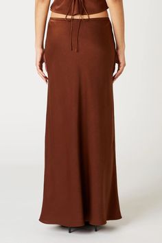 Ravello Skirt Color: Chocolate Satin bias cut slip skirt. Maxi length Elastic waistband Rosette accent and dainty scallop trim Pull-on style Lined 100% Poly | Model is wearing a size Small