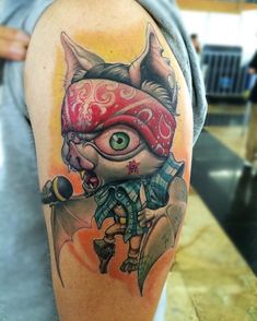 a man with a tattoo on his arm has an evil looking cat wearing a bandana