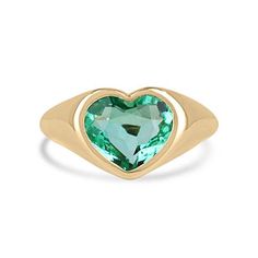 This ring is not for the faint of heart! Displayed is a Colombian emerald bezel-set, chunky signet ring in 18K gold. This gorgeous solitaire ring carries a full 2.19-carat emerald that will have you gazing at its mystic beauty. The emerald is incredibly crystal clear with a stunning freckle imperfection that adds the cutest beauty mark to this natural stone. This emerald will have you captivated at first glance.  Setting Style: Bezel-Solitaire Setting Material: Yellow Gold 18K Setting Weight: 4.2 Grams Main Stone: Emerald  Shape: Heart  Weight: 2.19-Carats Clarity: Transparent Color: Bluish Green Luster: Excellent Treatments: Natural, Oiling Origin: Colombia   Estimated Retail Value: $16,490.00 USD A certificate of appraisal is provided upon purchase. Keep in mind we custom create all of t Signet Pinky Ring, Heart Cut Ring, Emerald Cut Solitaire Ring, Colombian Emerald Ring, Beauty Mark, Solitaire Setting, Bezel Ring, Colombian Emeralds, Bluish Green